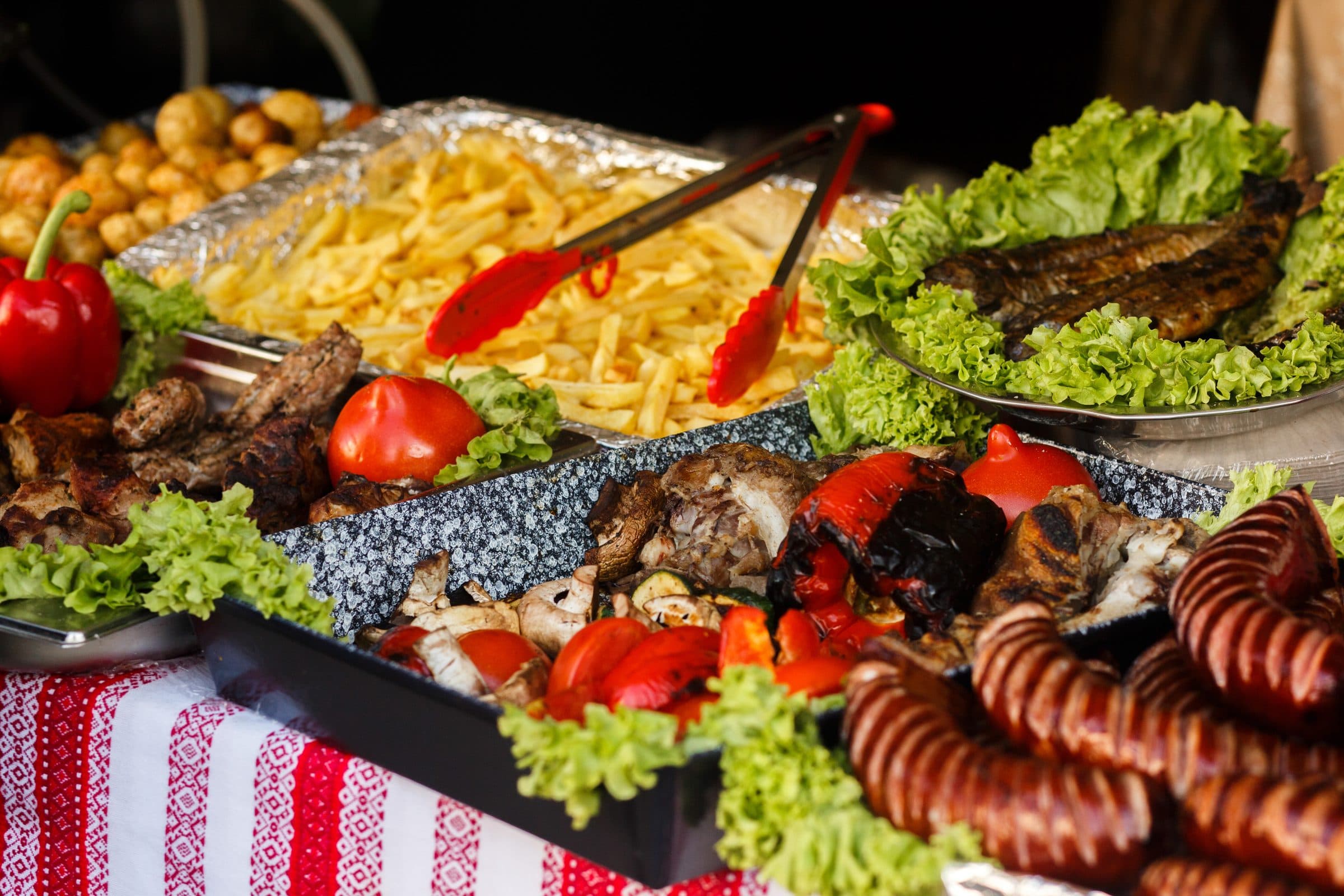 Bandejas de grelhados, fritas e saladas no buffet