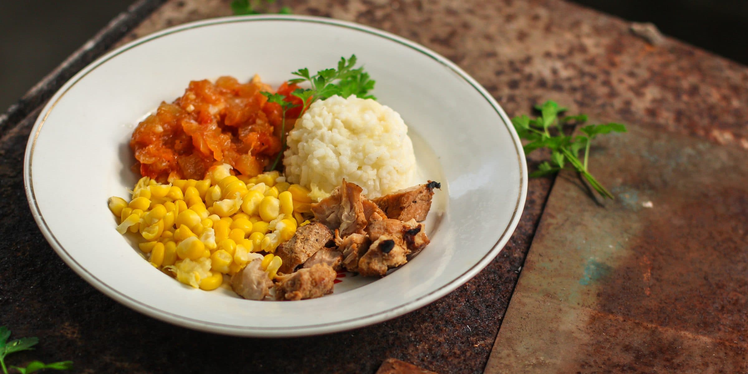 Prato com arroz, milho, frango e legumes