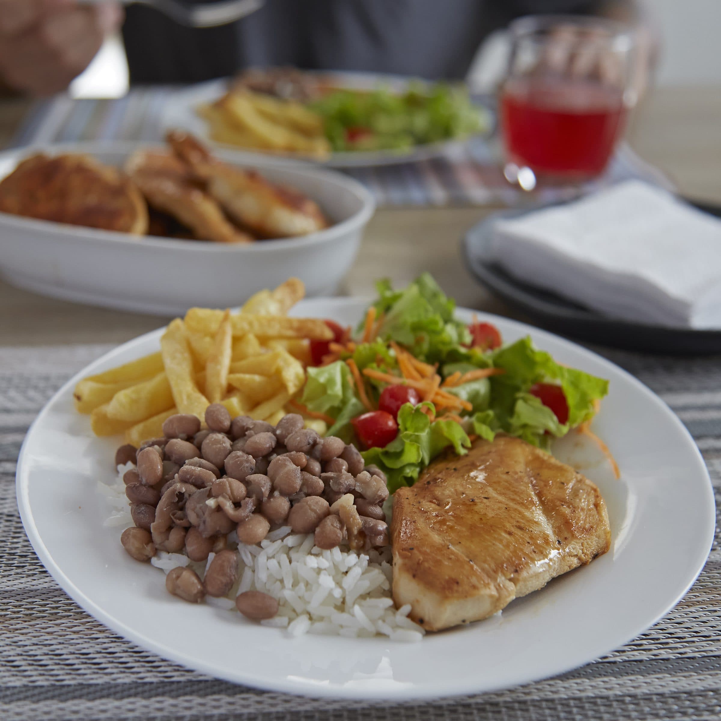Prato com feijão, arroz, frango e salada