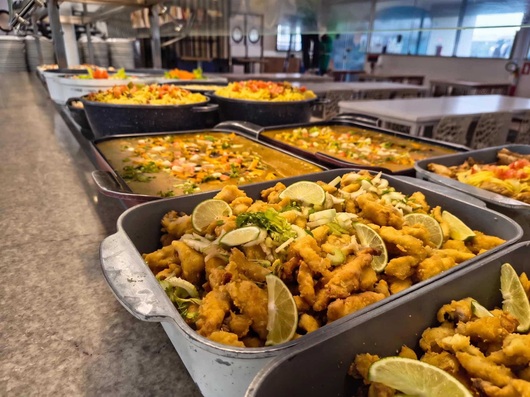 Buffet com refeições preparadas em cubas em um refeitório industrial